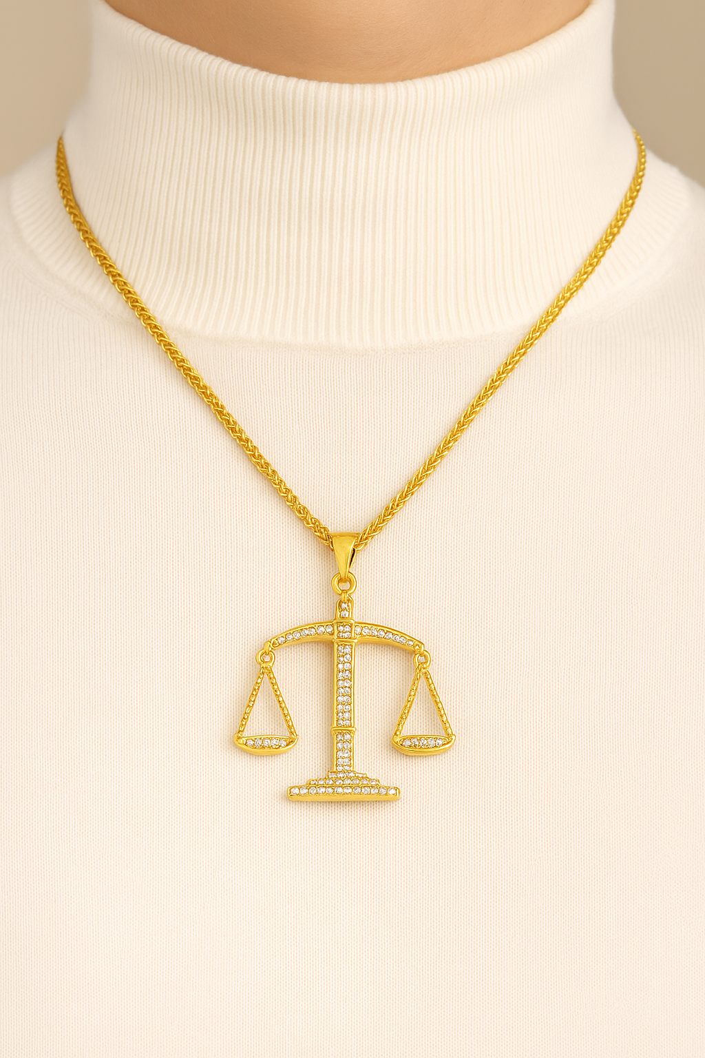 Pendentif Balance de la Justice doré porté sur col roulé clair, bijou symbolique du droit – Boutique Easy Droit